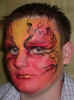 Face Painting: Adult male with full face painted in blended shades of red, orange, yellow and black providing a flaming effect.