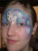 Face Painting: Adult female with silver and blue princess face punctuated with delicate daisies.