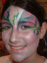 Face Painting: Adult female silvered green and lilac princess face highlighted with pink flowers.