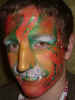 Face Painting: Adult male with orange and green tiger face.